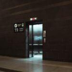 Open elevator in a modern airport terminal, showcasing sleek design and signage.